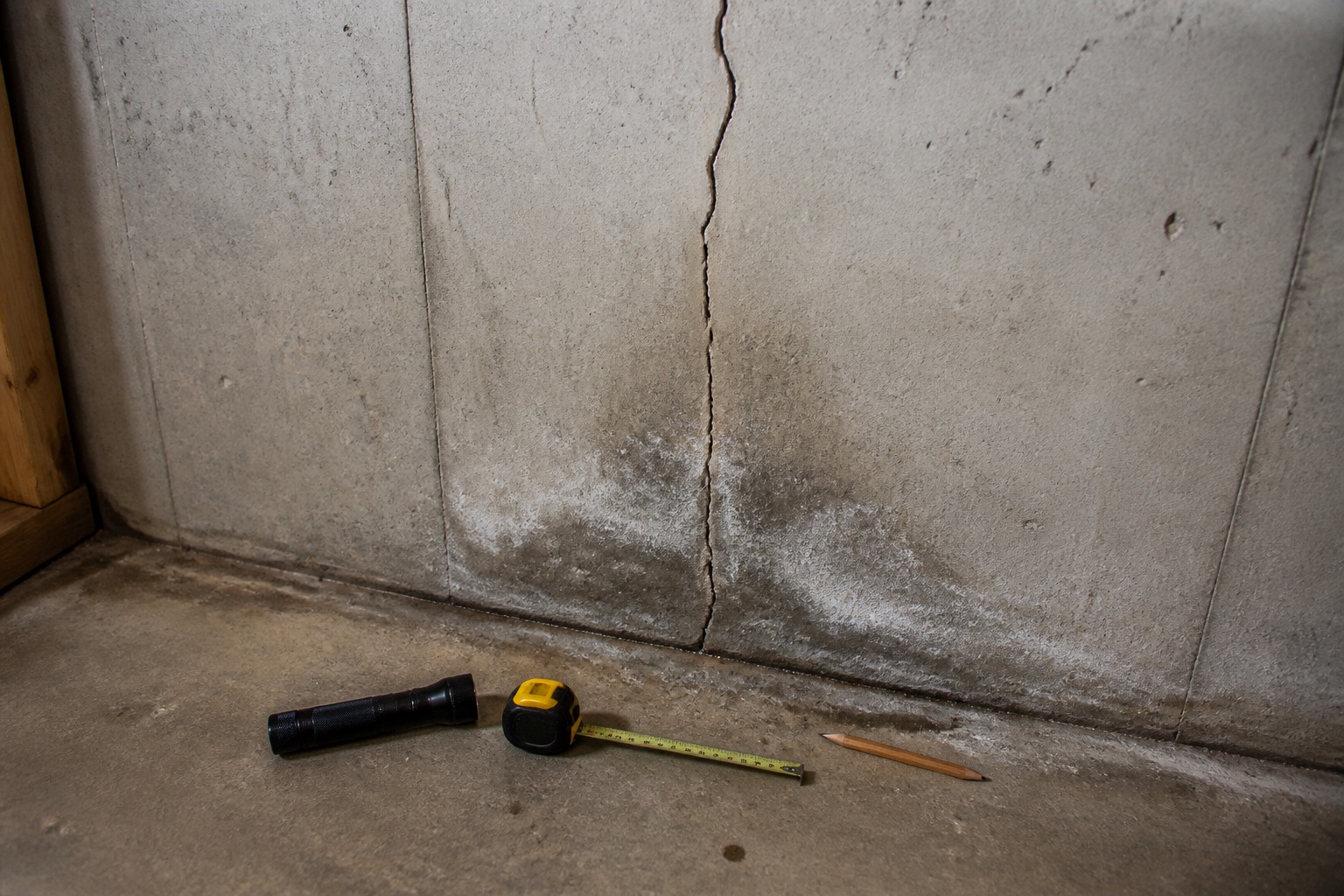 Foundation wall crack with water staining at the basement floor joint